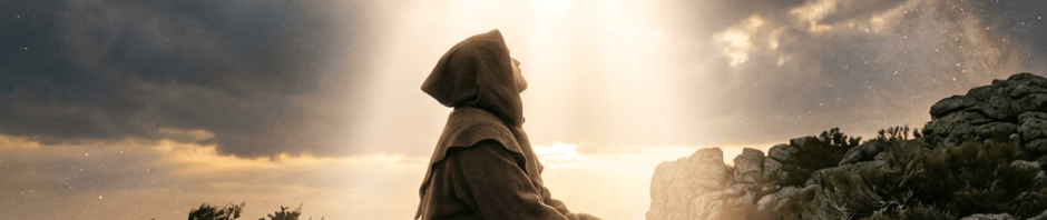Monk in brown robe sitting on rocks under bright radiant sky with light rays